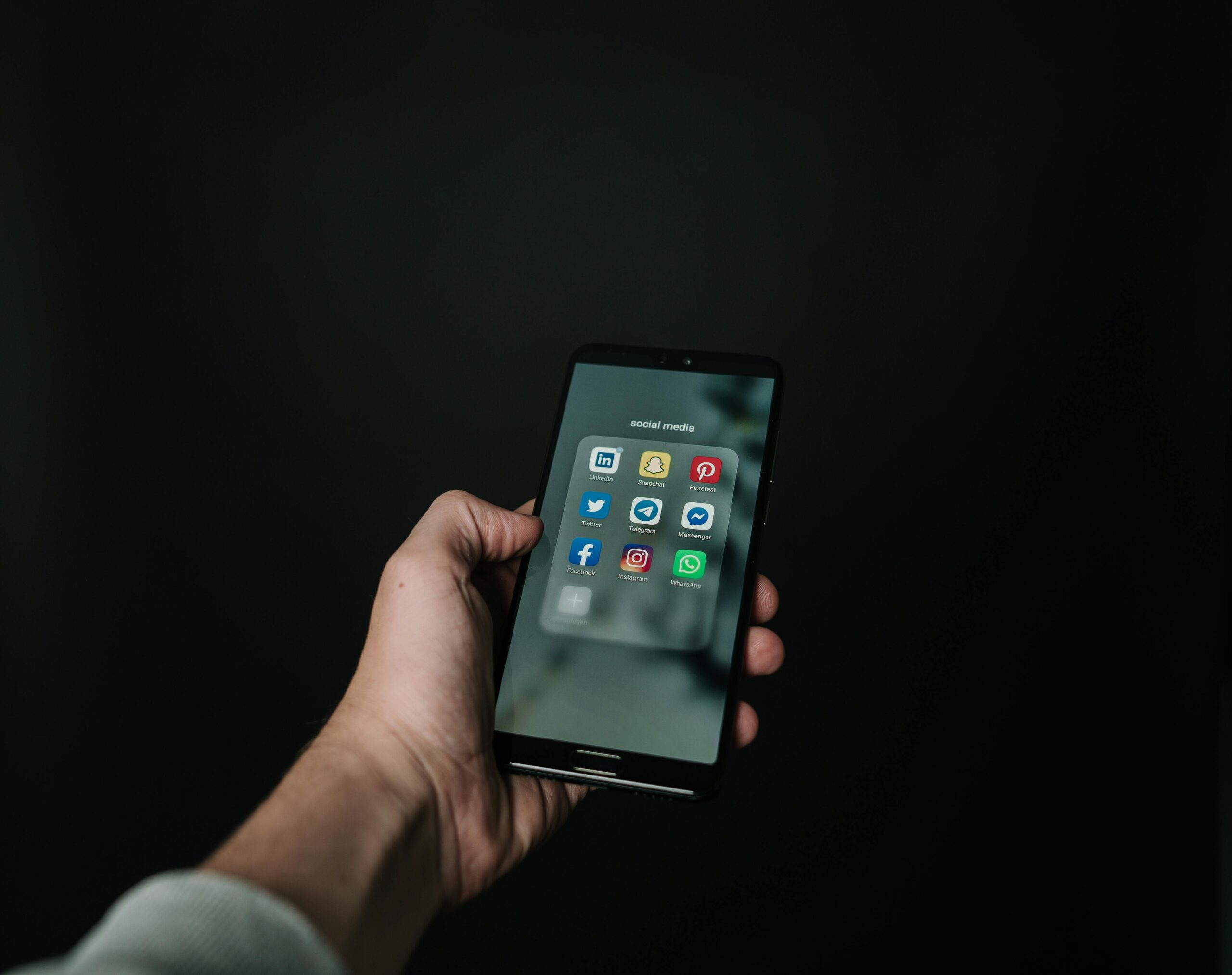 Hand holding a smartphone representing social media engagement strategies by web design firms