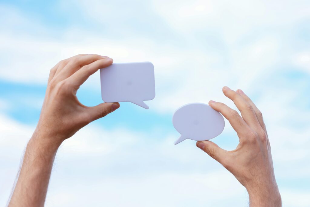 Paper cutouts of conversation clouds showing how web design firms use micro-engagement for deeper relationships