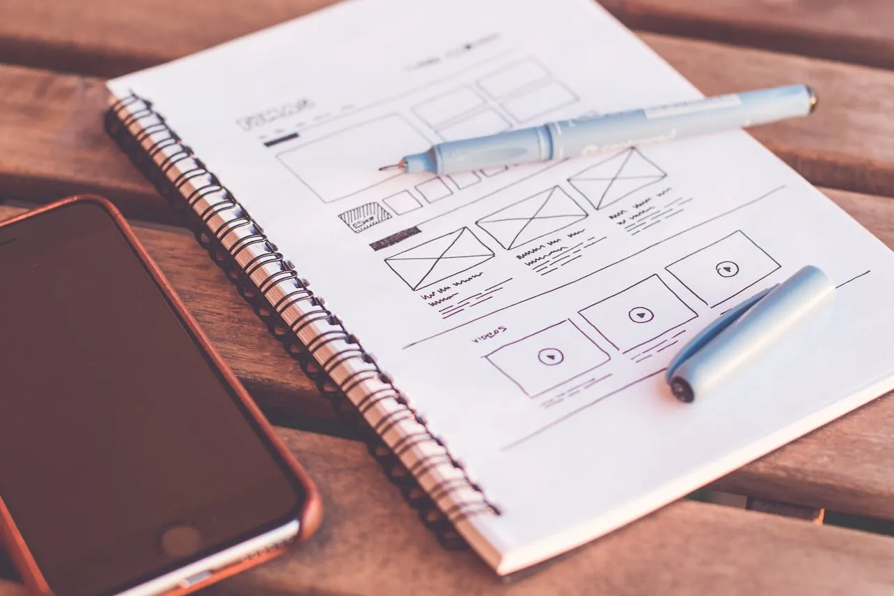 Spiral notebook with mobile-first website design and development wireframe sketches.