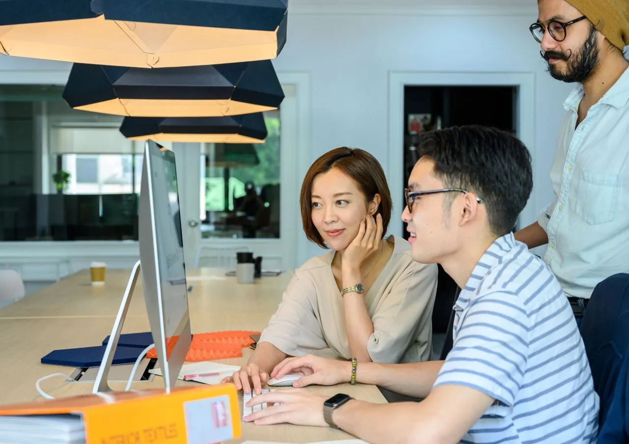 Asian website designers reviewing a customer journey and call-to-action layout