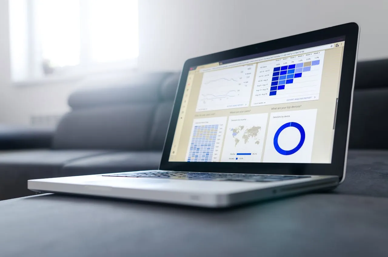Laptop displaying a digital marketing agency data analytics dashboard with charts and graphs, including bar and pie charts.