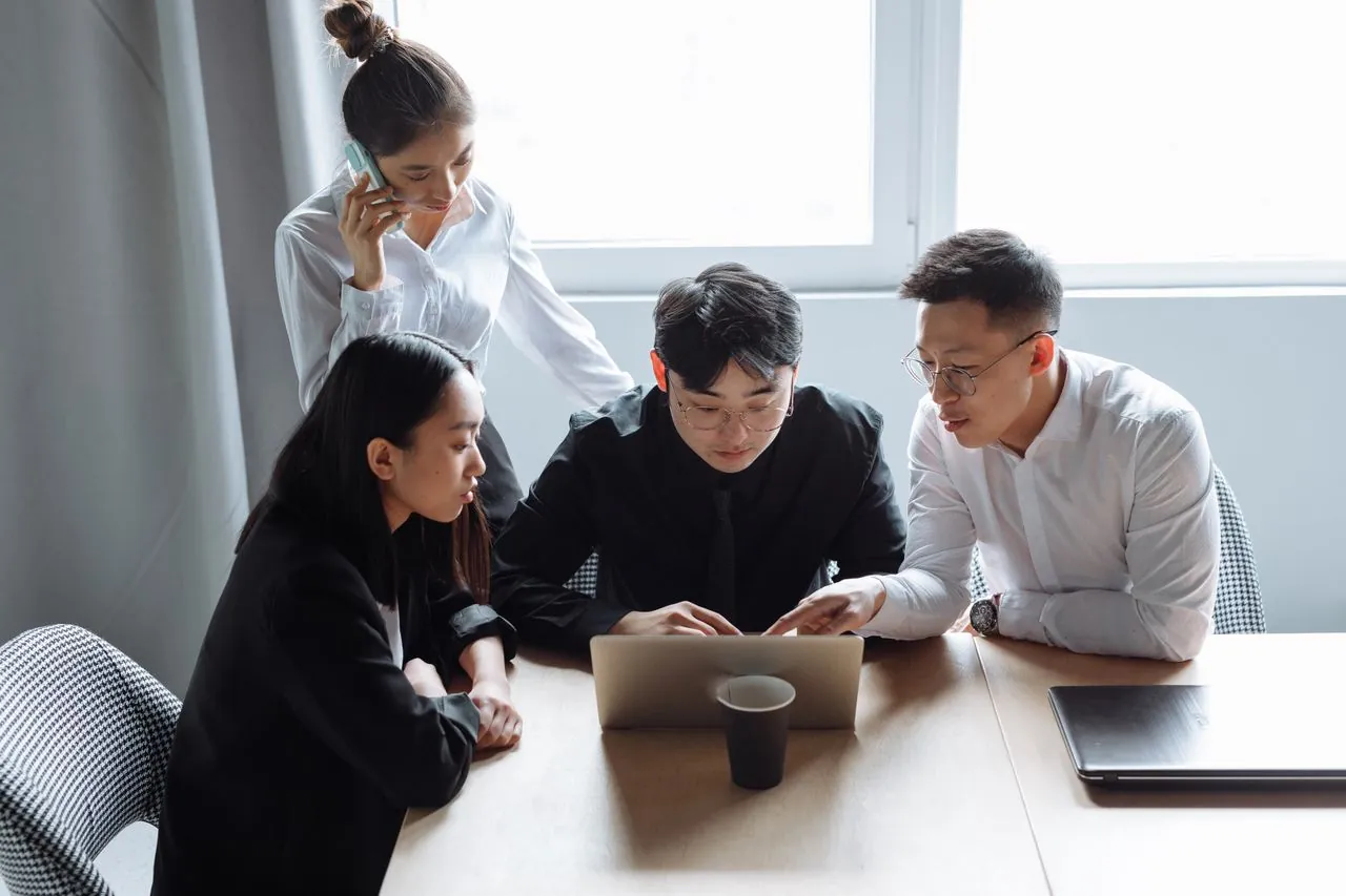 Team of website designers reviewing a website on a laptop.