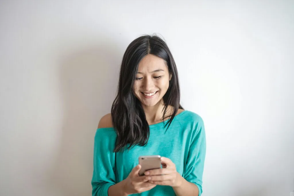 We see an asian woman looking and deeply immersed in her mobile screen. An important aspect to consider when designing and developing websites.