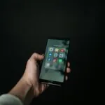 Hand holding a smartphone representing social media engagement strategies by web design firms