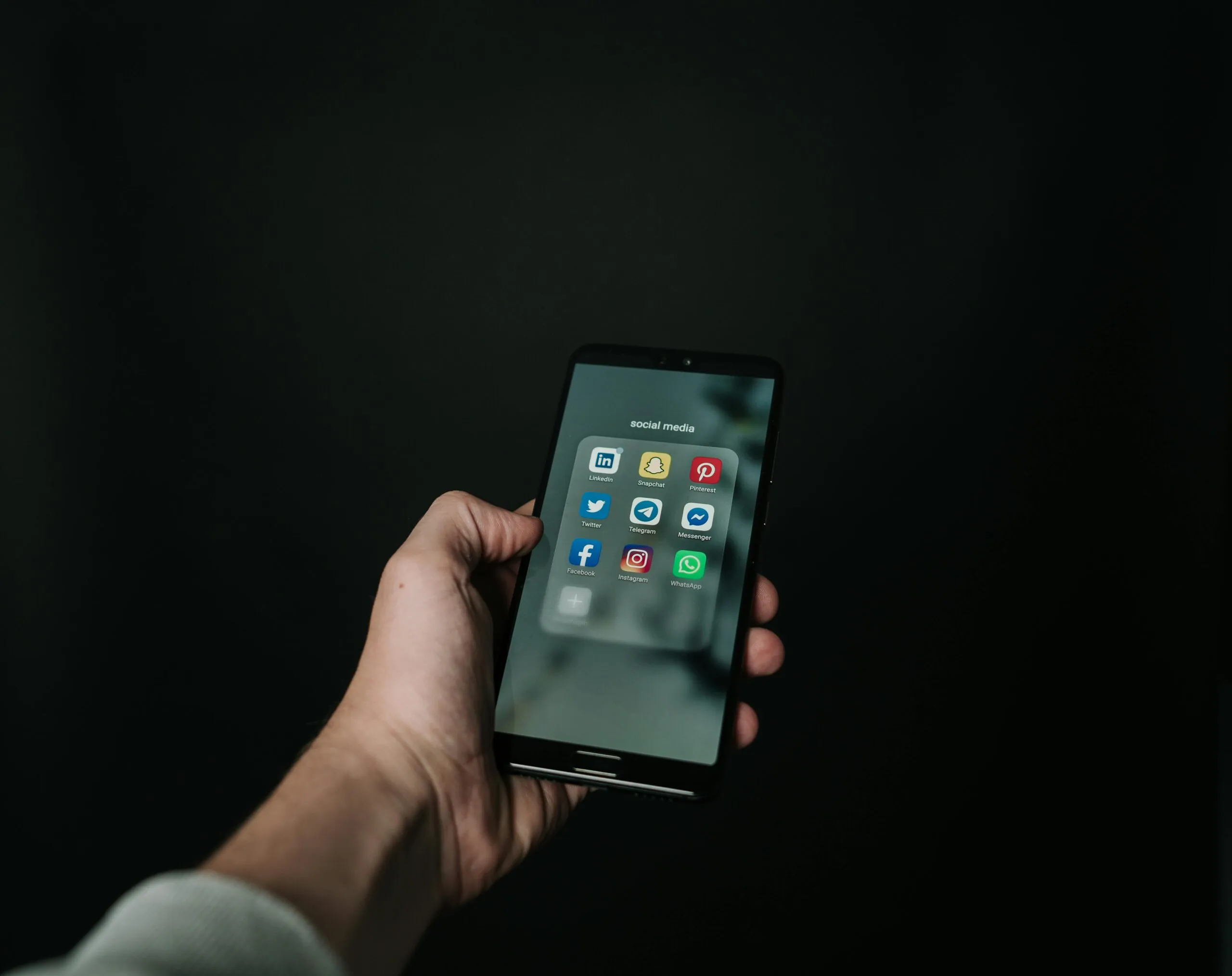 Hand holding a smartphone representing social media engagement strategies by web design firms